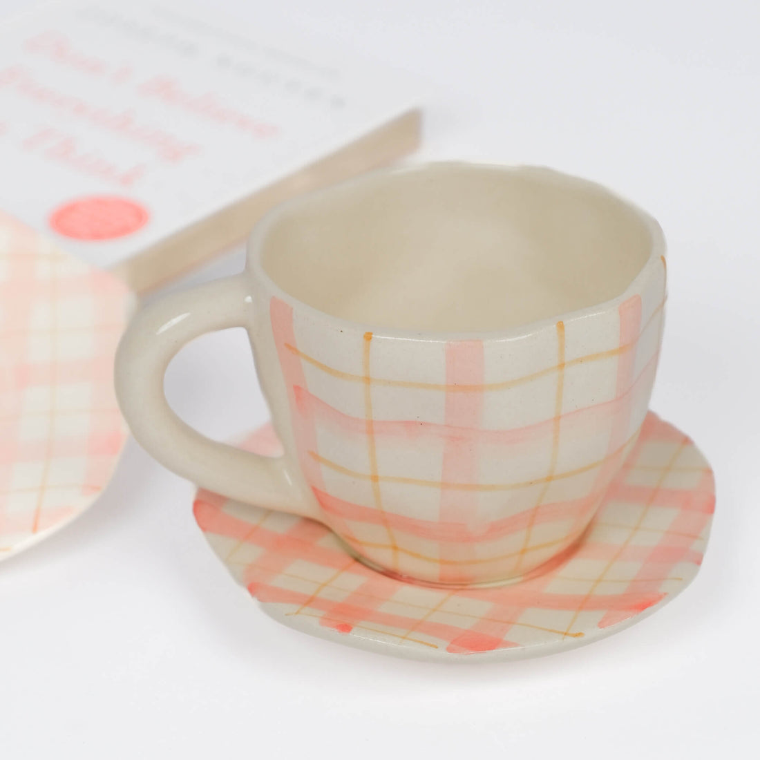 Pink checkered ceramic cup and saucer